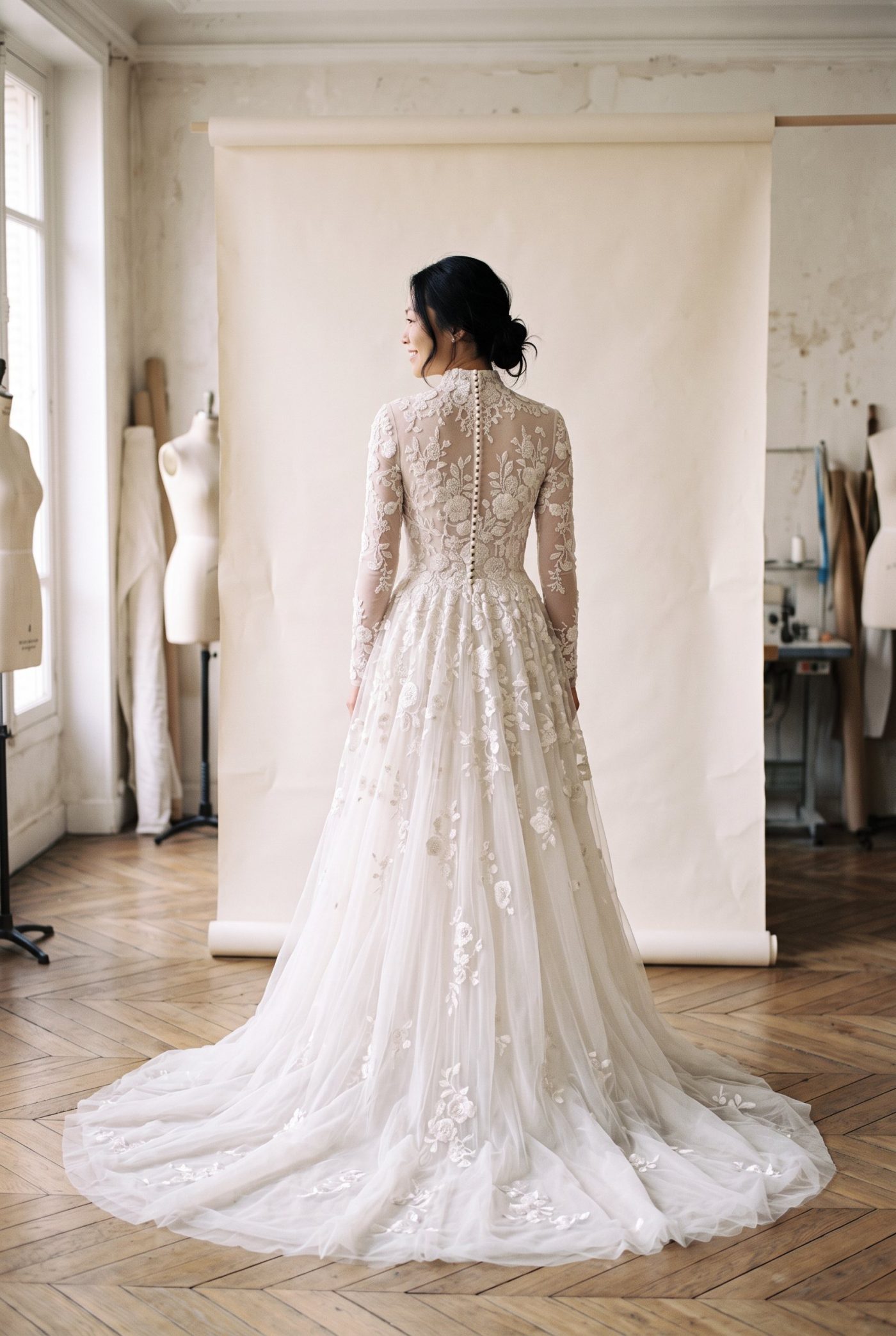 Robe de mariée Point de bourdon vue de dos, devant un fond de papier écru